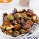 Completed brussels sprouts recipe on a white dinner plate.