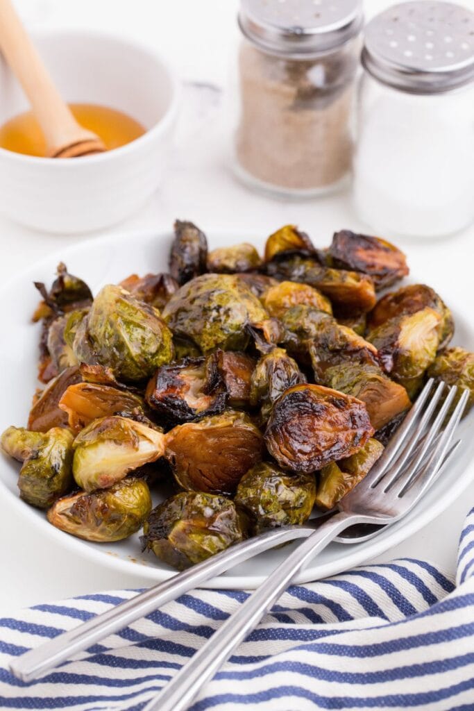 Completed brussels sprouts recipe on a white dinner plate.
