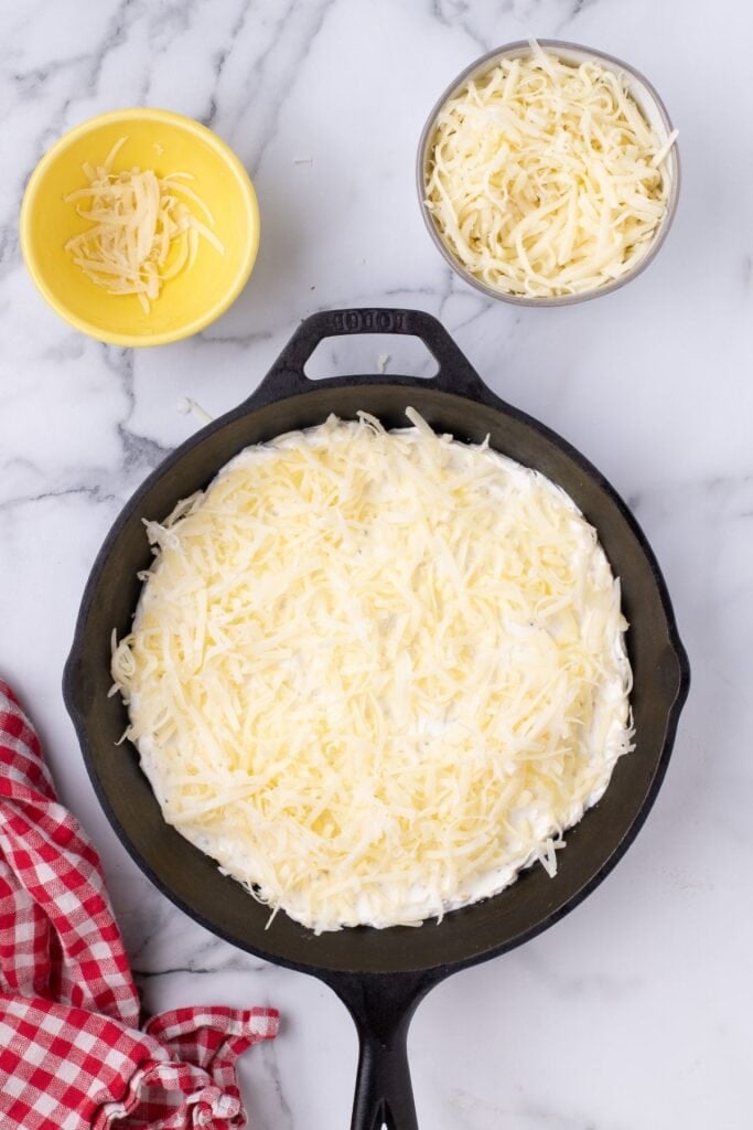 Shredded mozzarella cheese is layered on top of the cream cheese mixture.