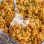 A serving spoon is scooping out a helping of casserole.