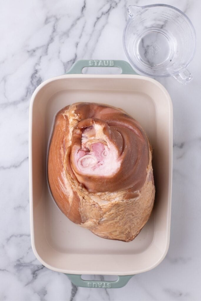 Ham shank in a large baking pan.
