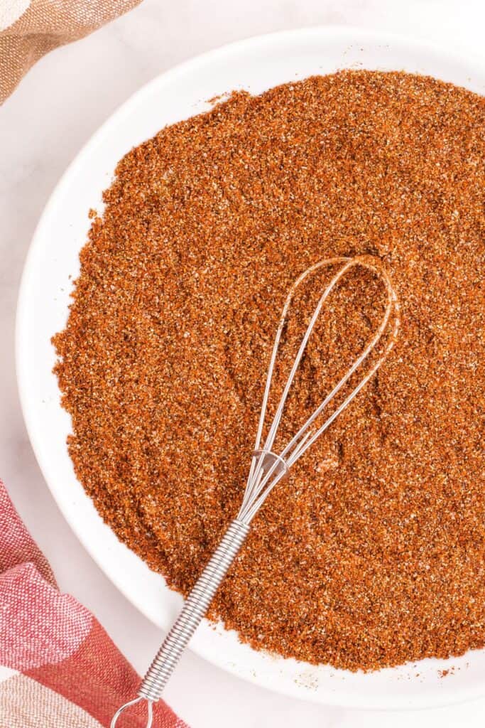A white serving bowl with chili seasoning in it.