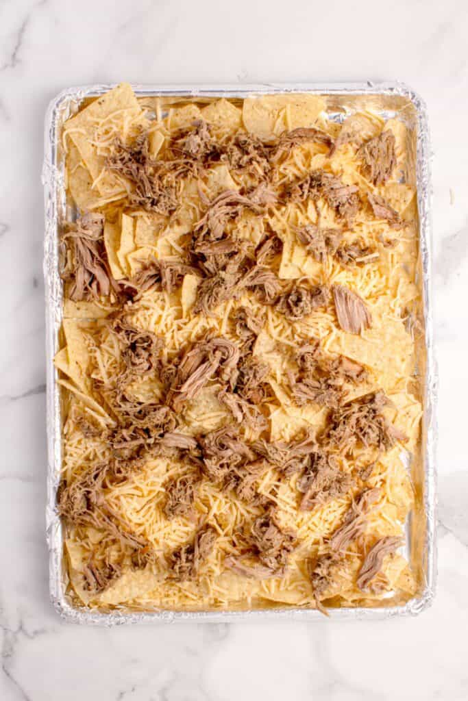 Tortilla chips topped with shredded cheese and pulled pork.