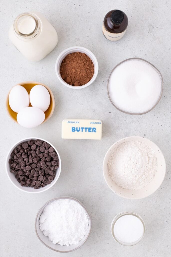 Ingredients for football brownies: heavy cream, vanilla, cocoa powder, sugar, butter, eggs, flour, chocolate chips, powdered sugar, and salt.