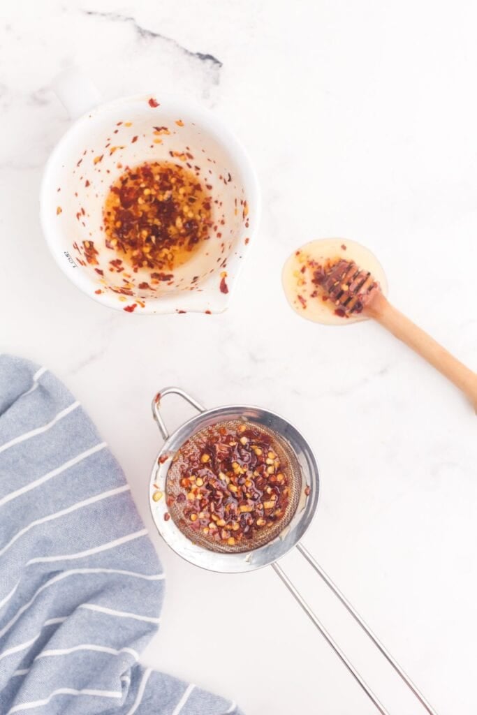 Hot honey strained through a sieve to remove red pepper flakes.