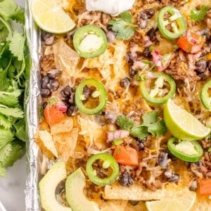 Completed oven nachos on an aluminum foil covered baking sheet.