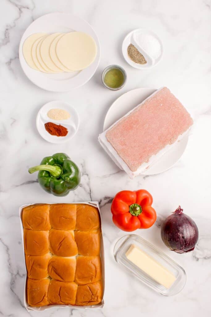 Ingredients for philly cheesesteak sliders: Hawaiian rolls, butter, onion, bell peppers, shaved steak, oil, salt, black pepper, garlic powder, and smoked paprika.