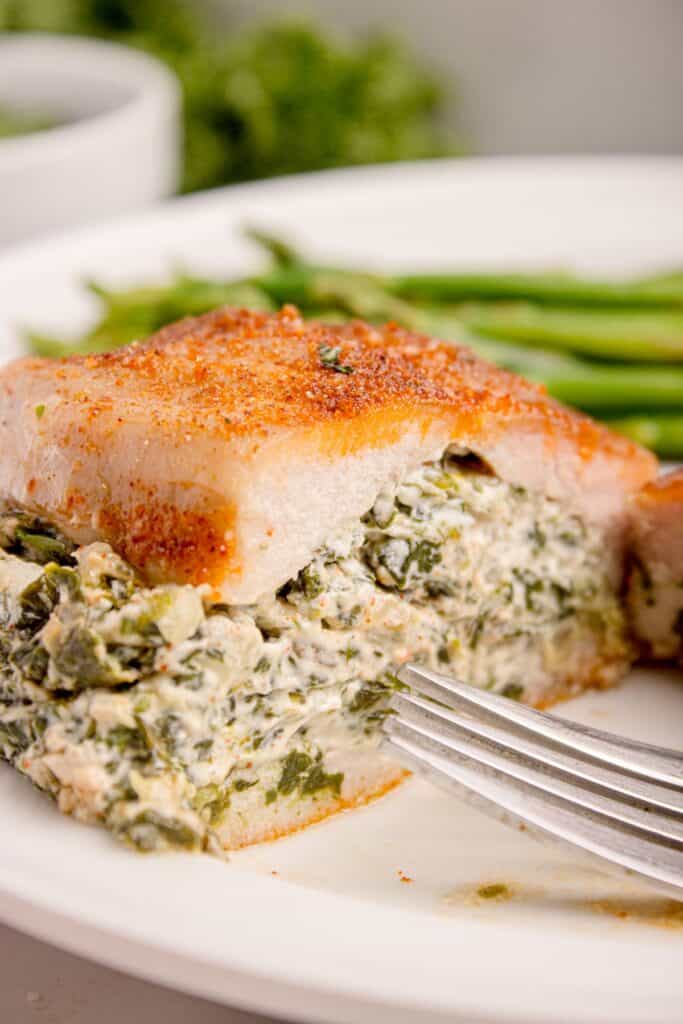 Cooked stuffed pork chops sliced in half to show interior.