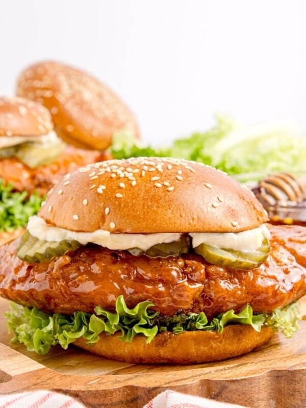 Completed hot honey chicken sandwich on a wooden cutting board.