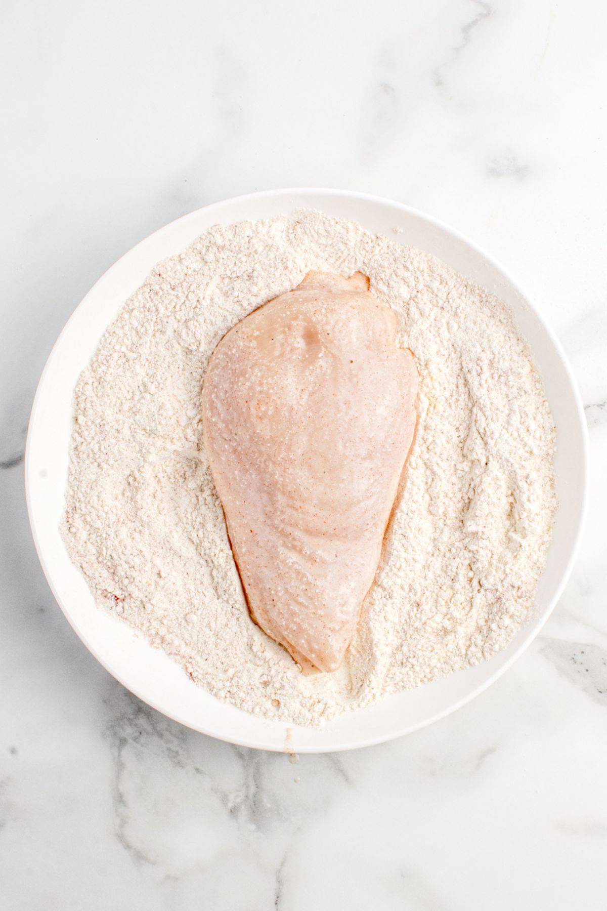 Chicken breast dredged in flour.