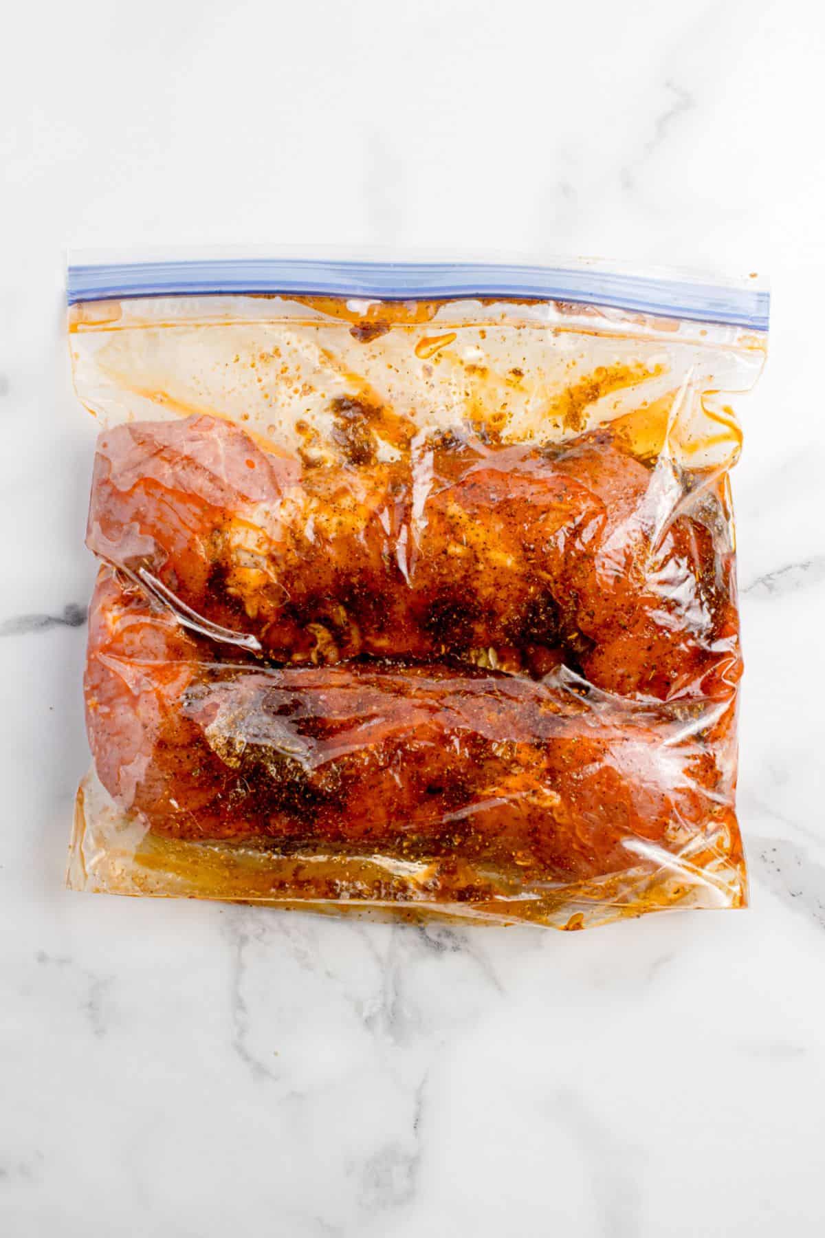 Massaged pork tenderloins and marinade in a zip top bag.
