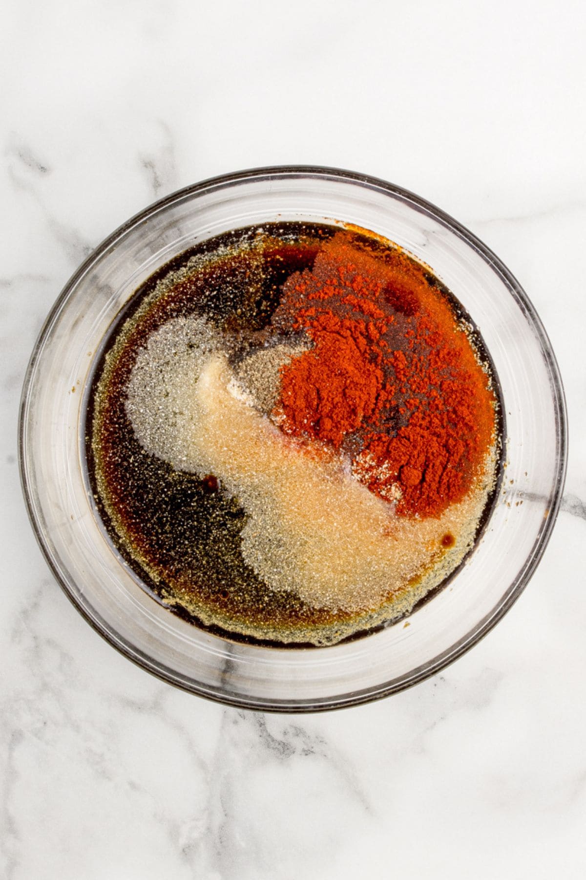 Marinade for pork chops in a glass mixing bowl.