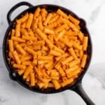 Sauce and pasta are mixed together to complete pasta recipe.
