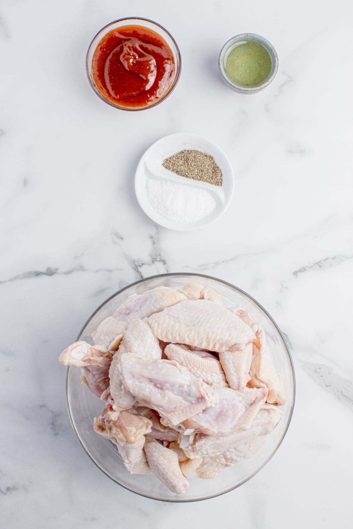 Ingredients for BBQ chicken wings: chicken wings, olive oil, salt, black pepper, and barbecue sauce.