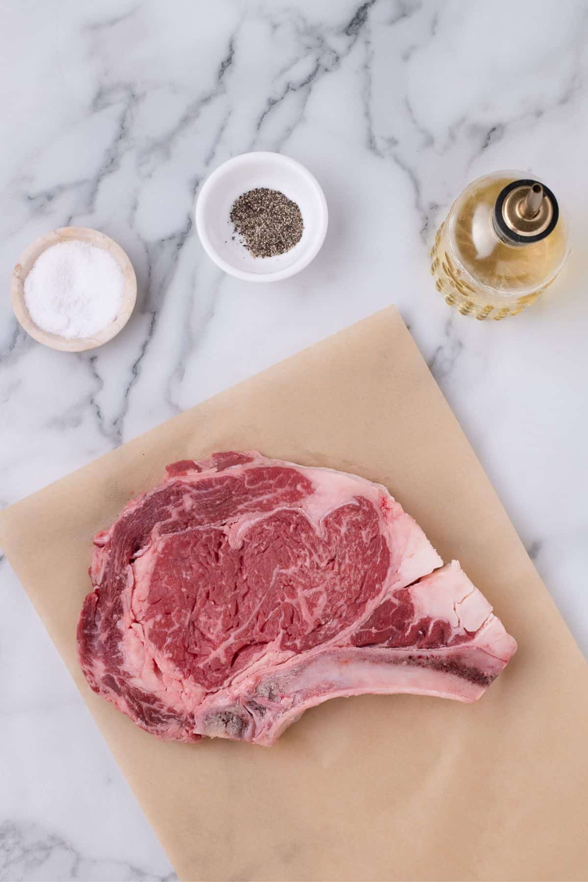 Ingredients for bone-in ribeye steak: Ribeye steak, salt, pepper, and oil.