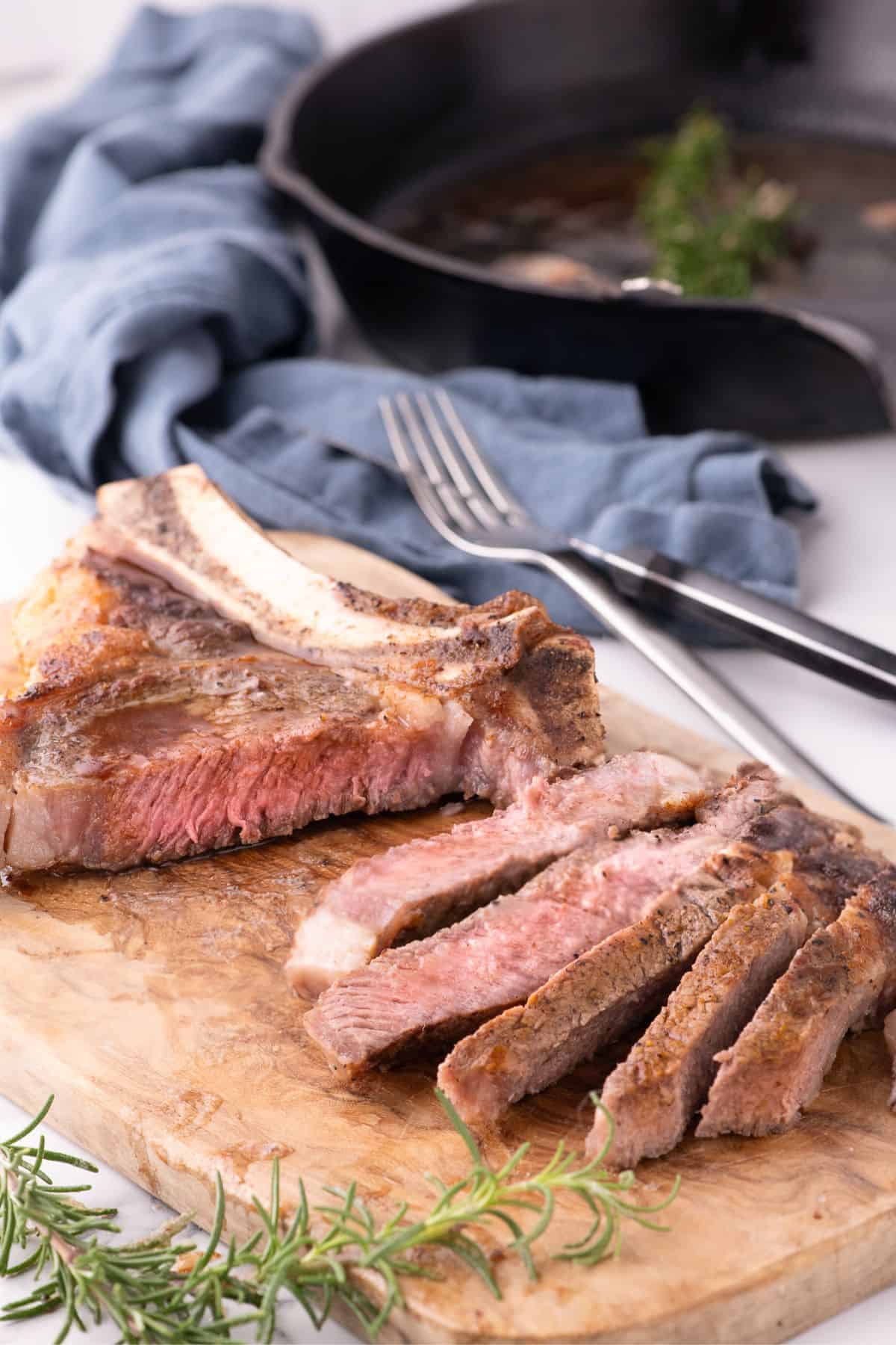 Sliced ribeye steak on a wooden cutting board.