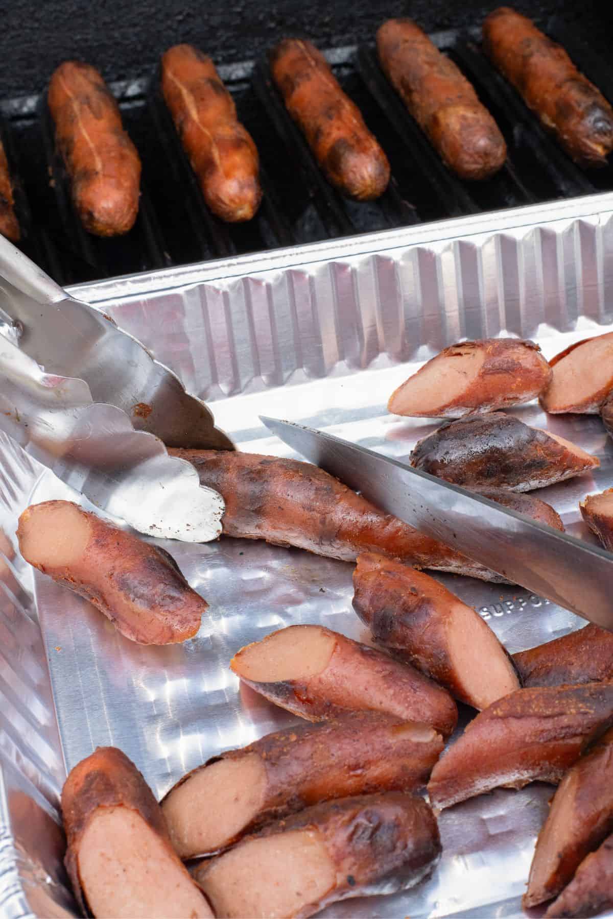 Hot dogs being sliced into thirds.