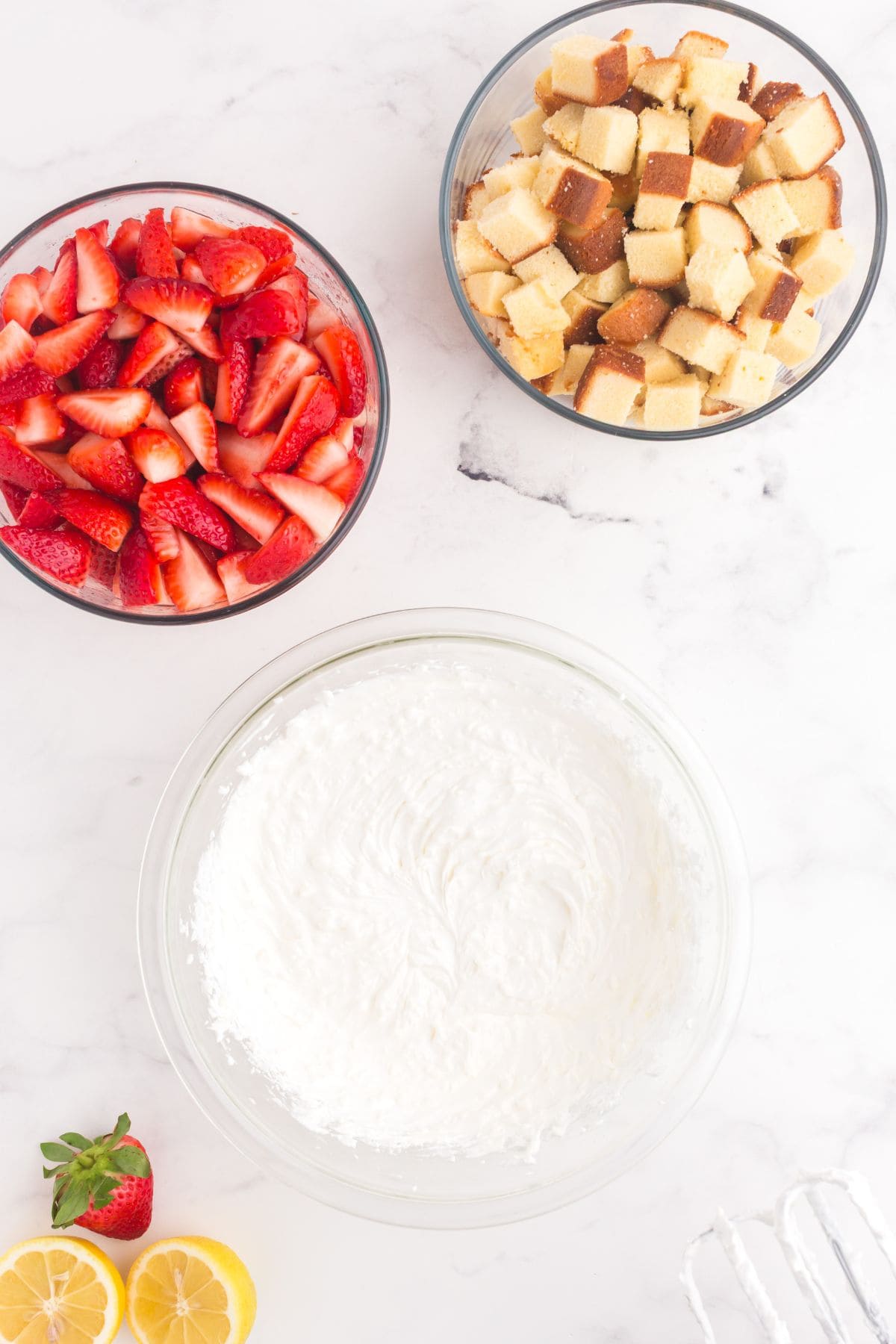 Combined whipped cream mixture in a glass bowl with Cool Whip, cream cheese, lemon, and sugar.