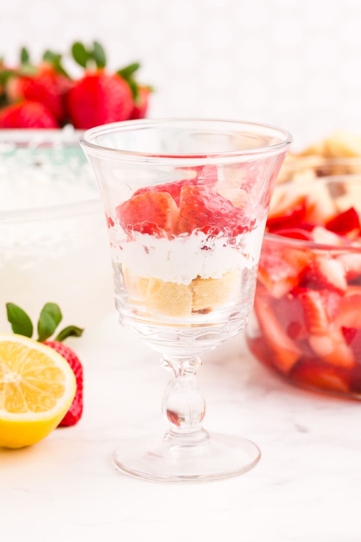 Cut strawberries layered on top of whipped cream and pound cake.