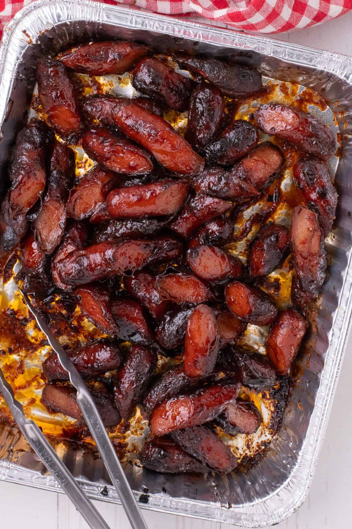 Hot dog burnt ends in a aluminum baking dish.