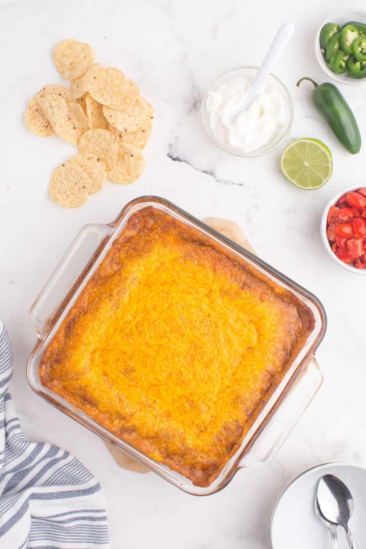 Overhead shot of the refried bean dip with melted and golden brown cheese on top.