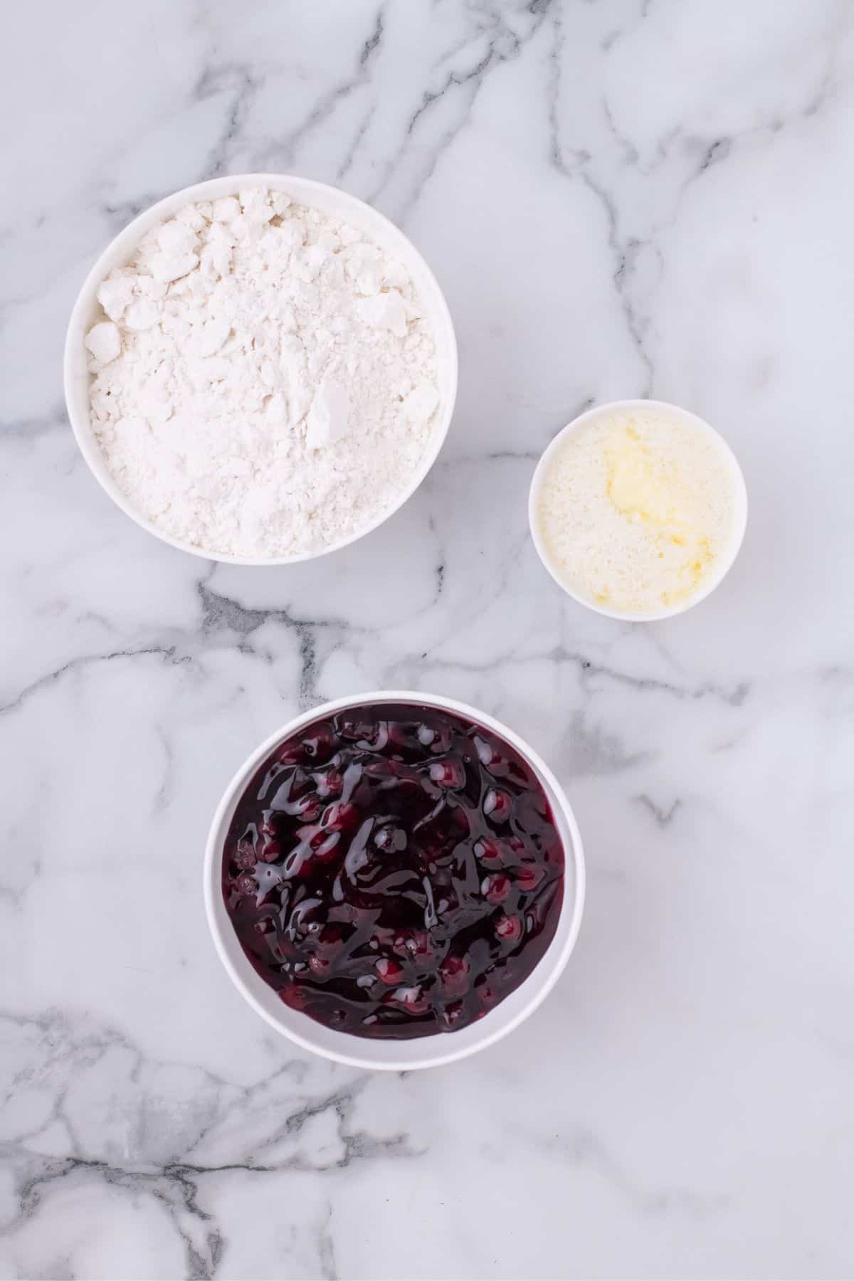 Ingredients for blueberry cobbler with cake mix: vanilla cake mix, butter, blueberry pie filling.