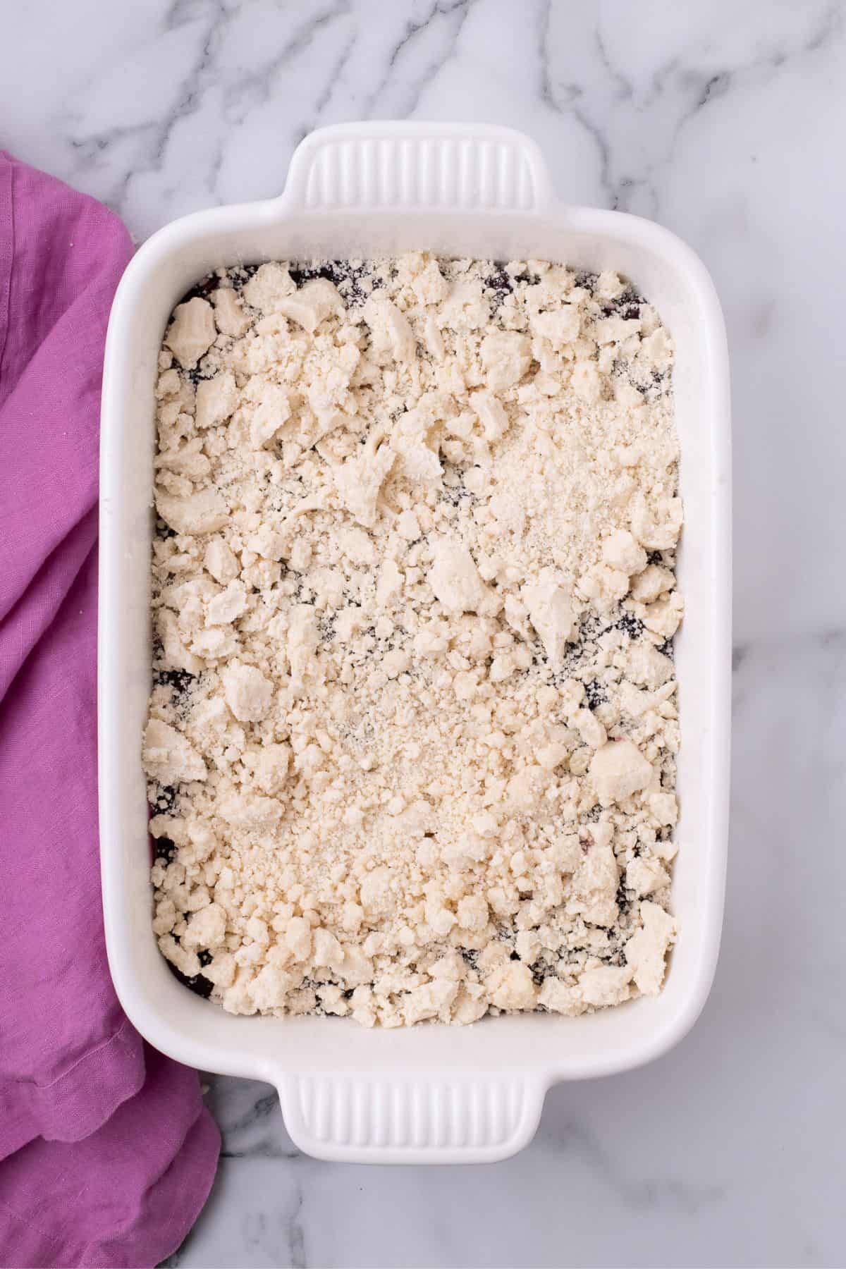 Crumbled cake mix is layered on top of the blueberry pie filling.