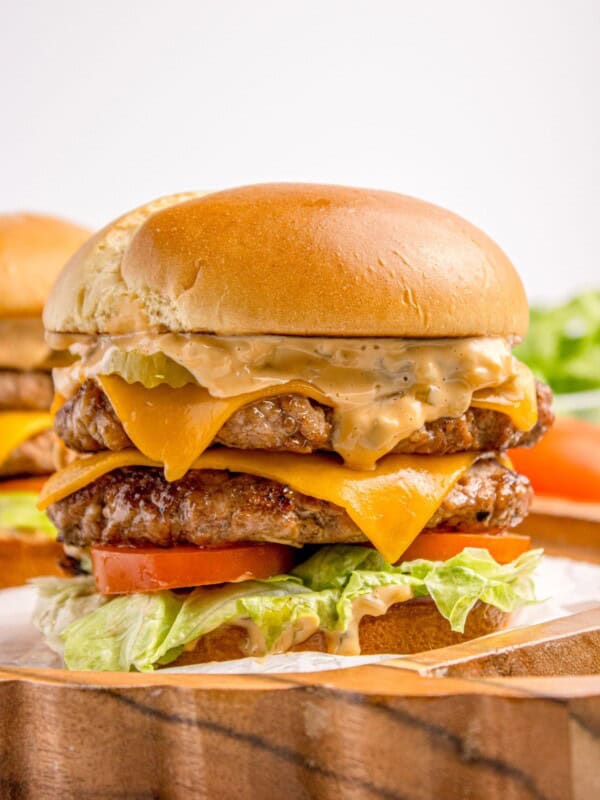 Completed smash burger on a wooden platter.