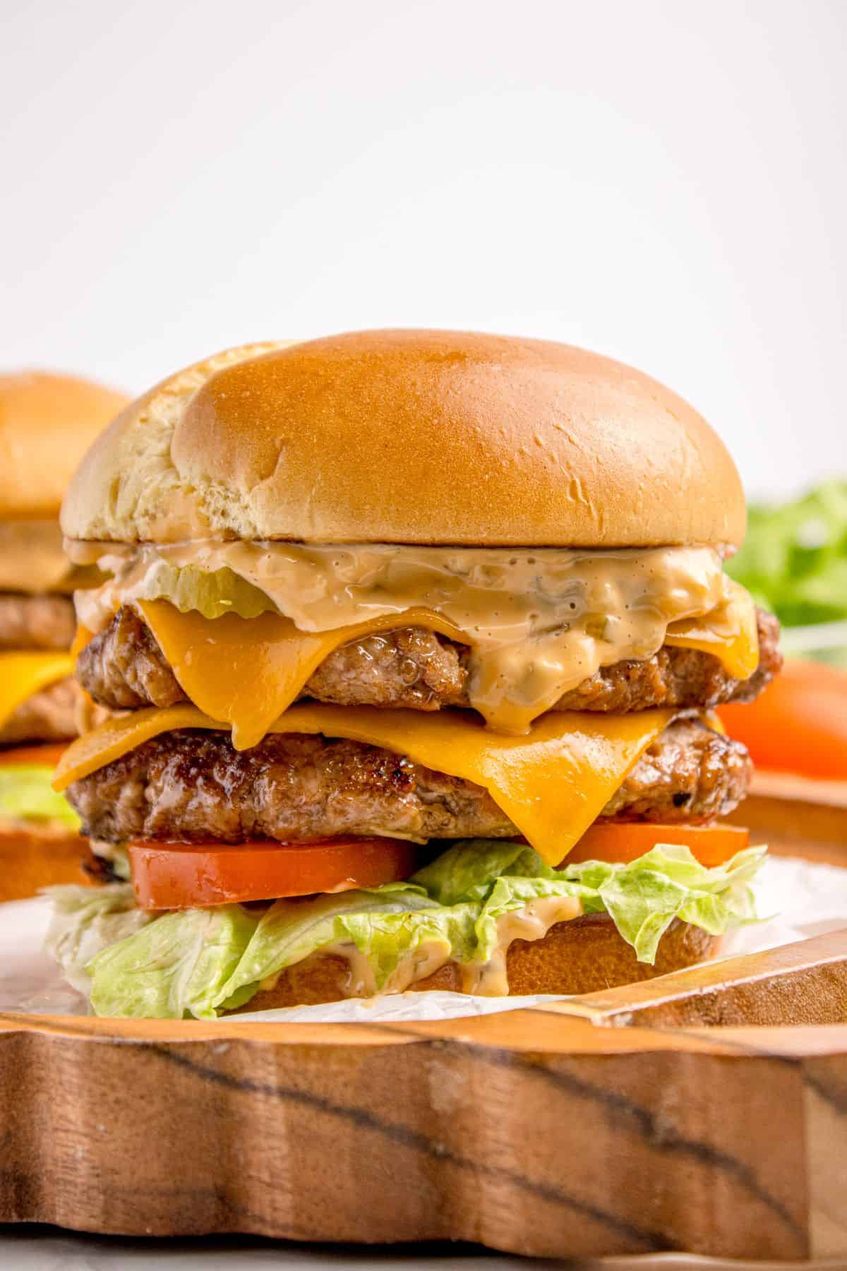 Completed smash burger on a wooden platter.