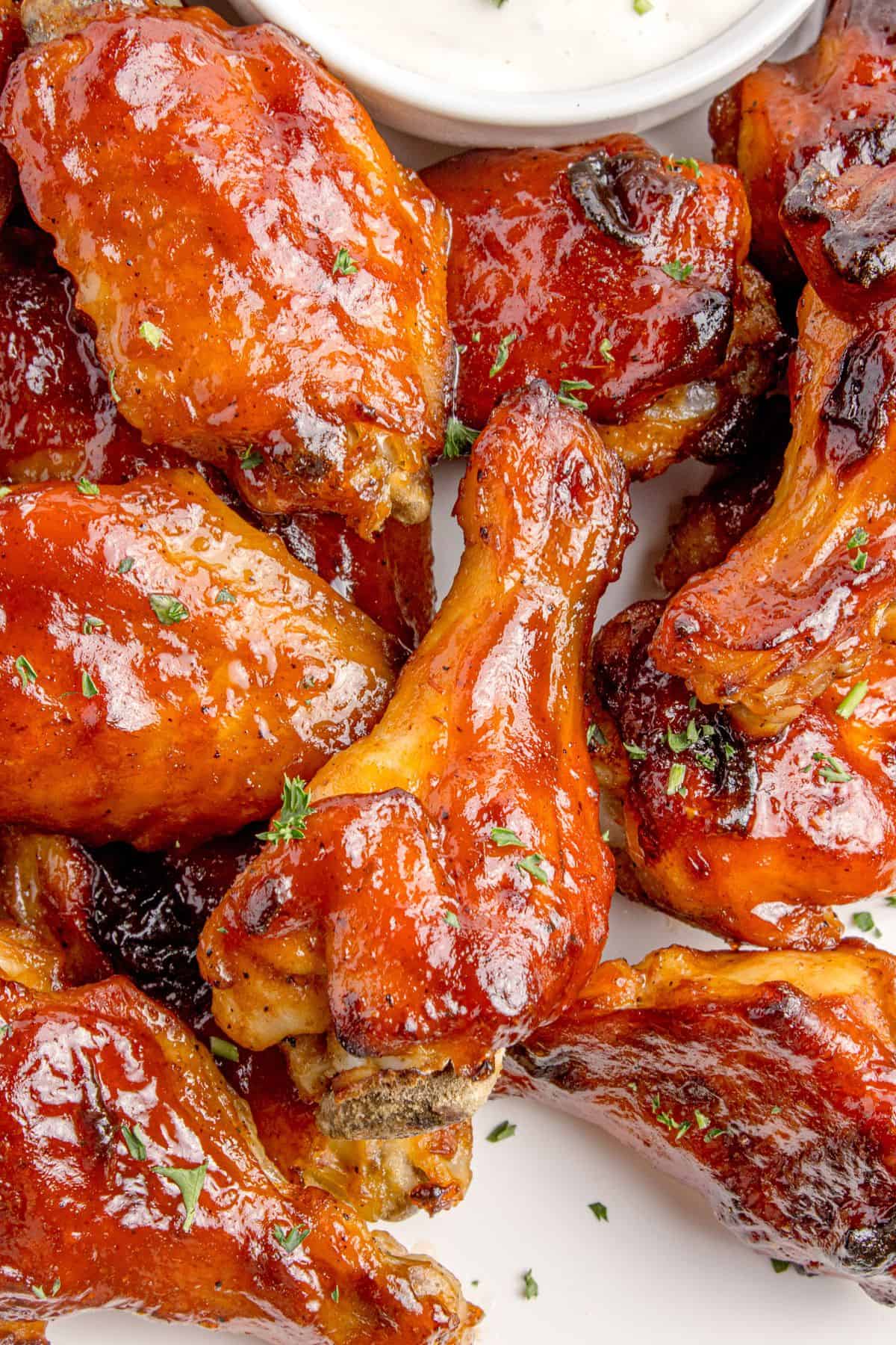 Close up of BBQ wings on a serving plate with blue cheese.