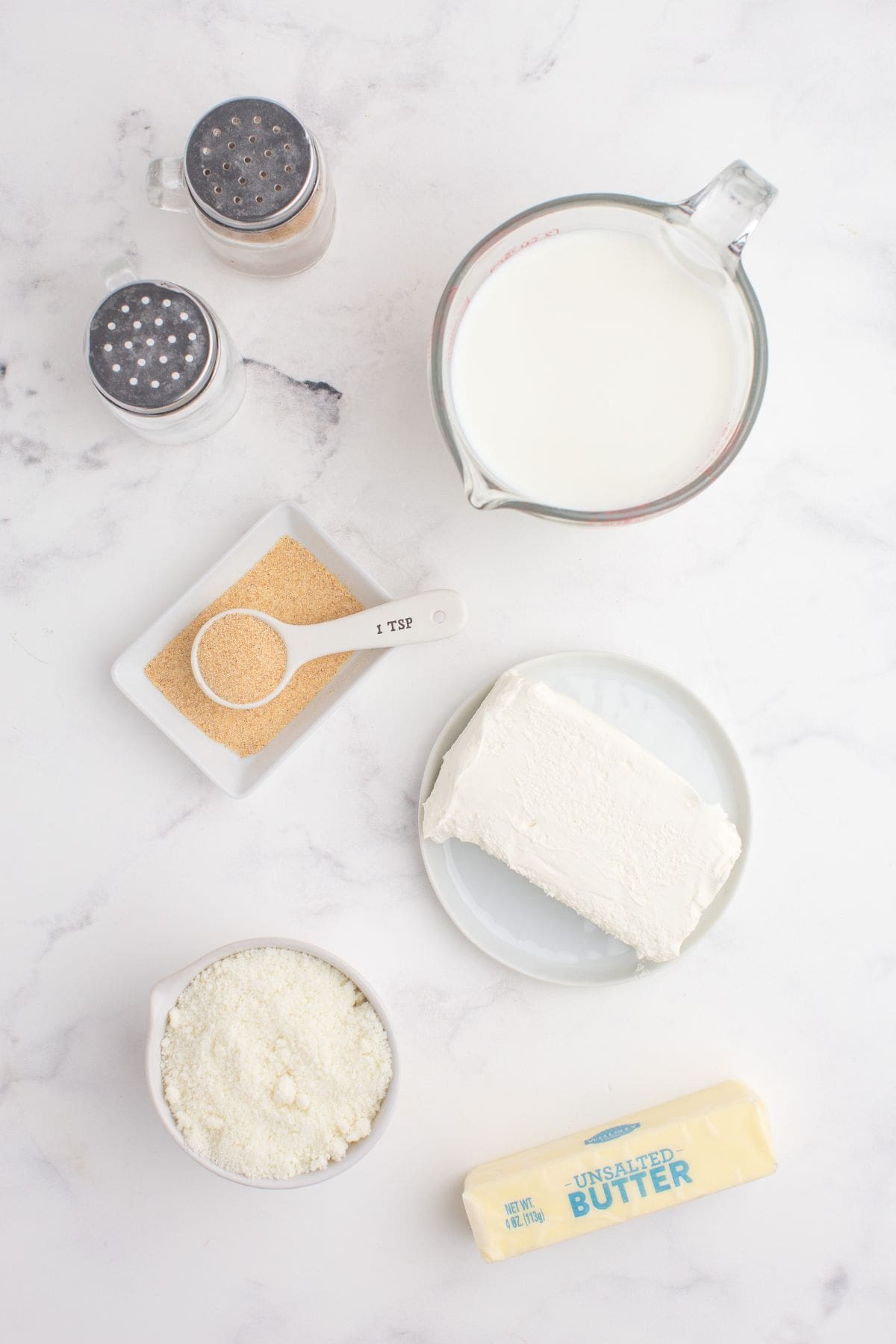 Ingredients for alfredo sauce with cream cheese: Milk, cream cheese, butter, parmesan cheese, garlic powder, salt, and pepper.