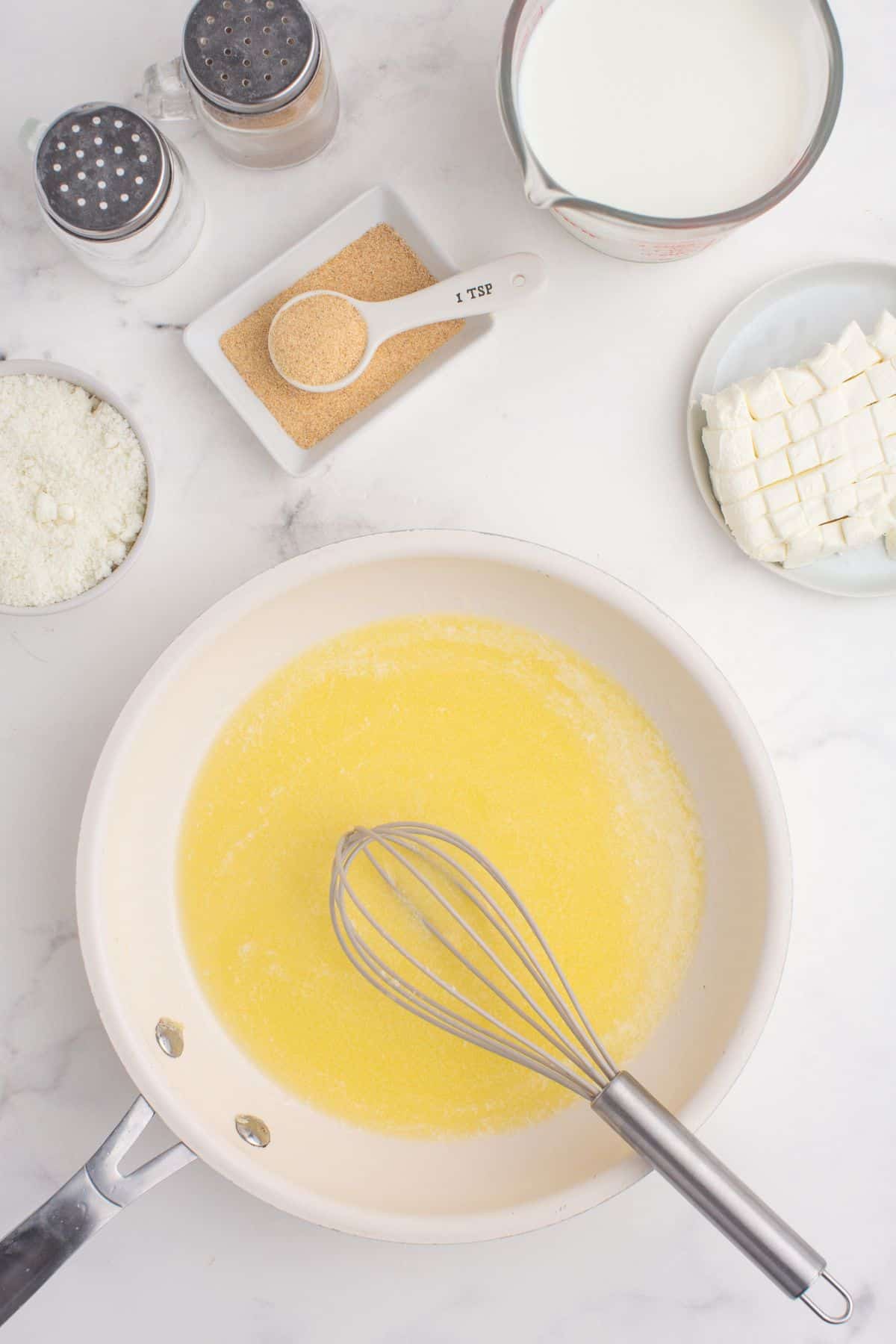 Melted butter at the bottom of a large skillet.