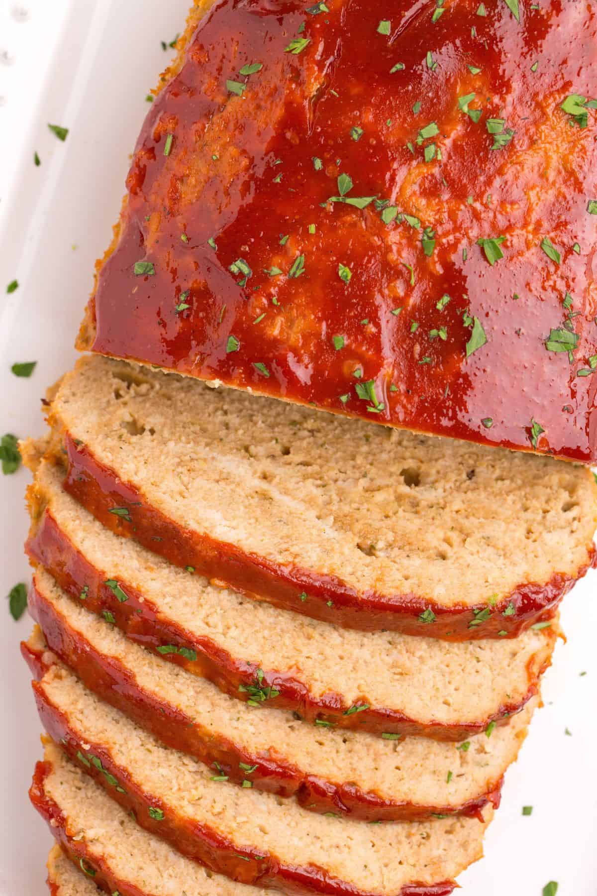 Closeup of the chicken meatloaf with half sliced.
