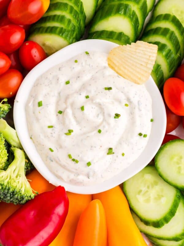 Overhead view of the ranch dip surrounded with veggies and a chip inside the dip in the middle.