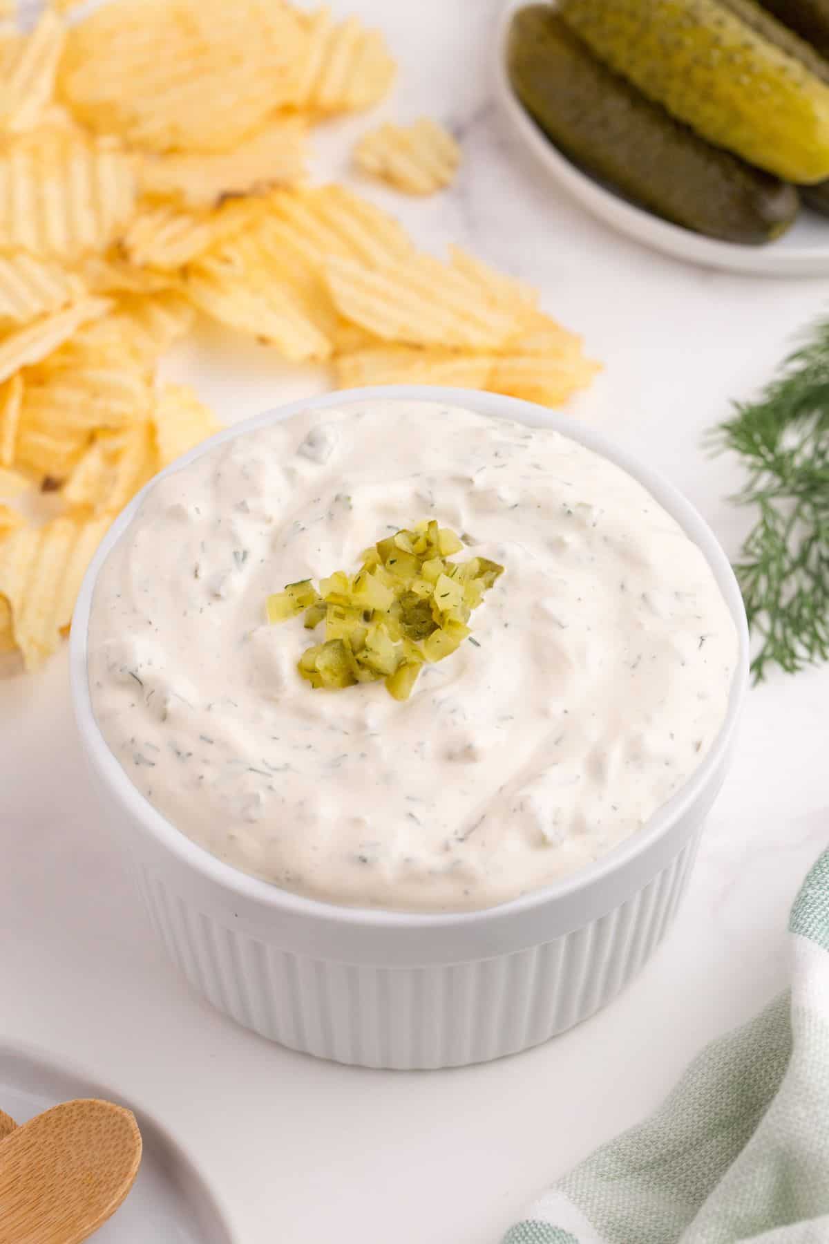 Completed dill pickle dip in a white ramekin.