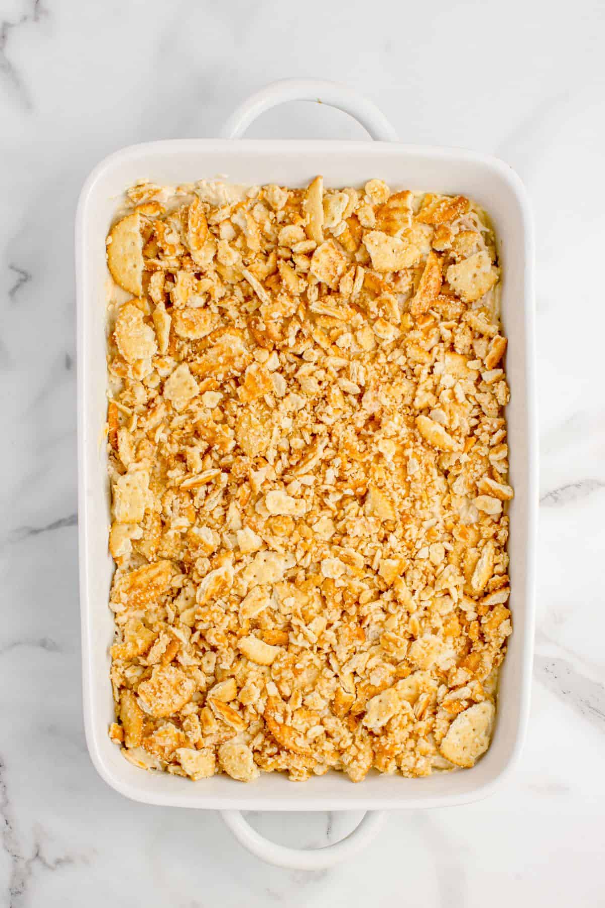 Chicken casserole with ritz crackers ready to be baked.